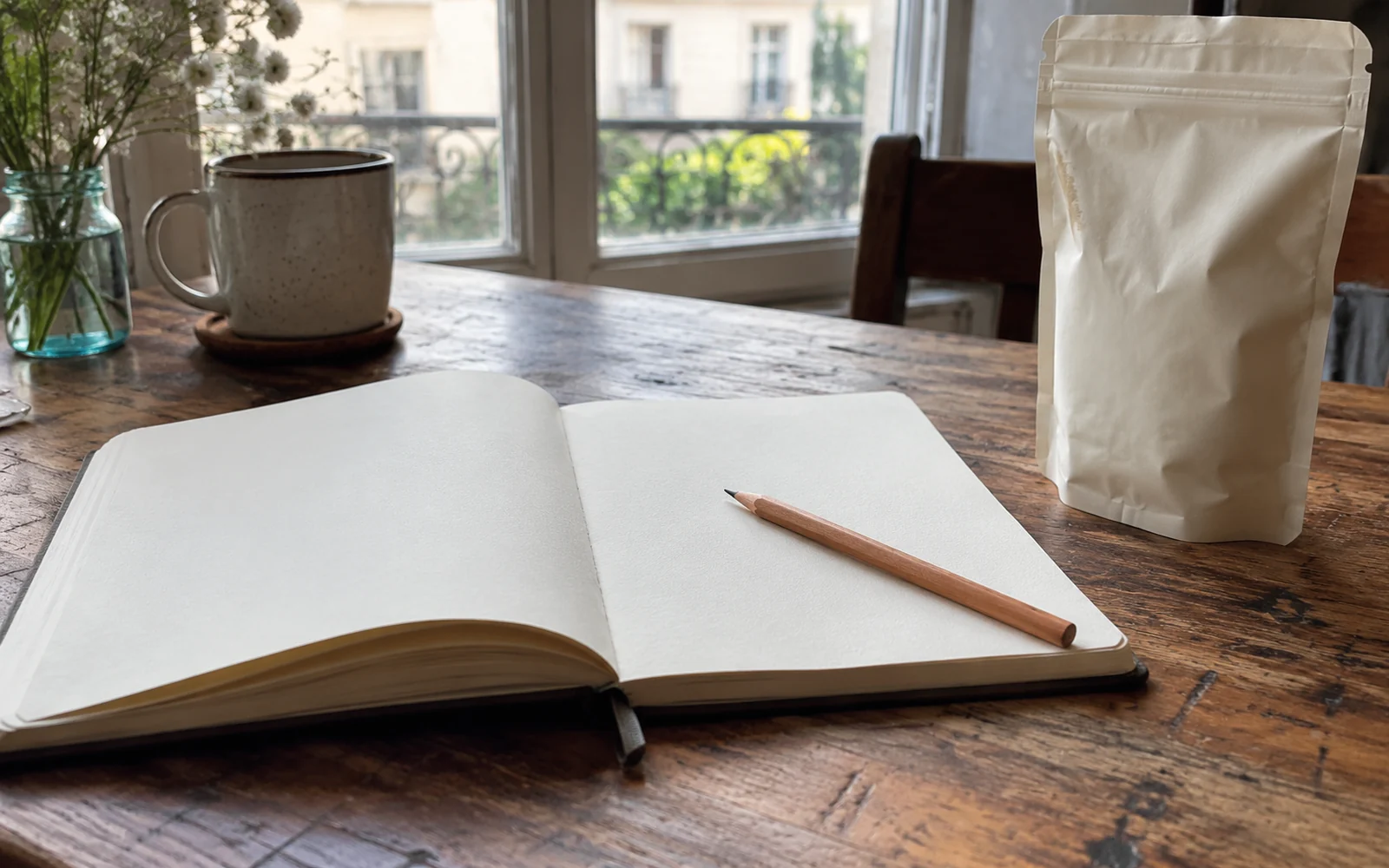 Un carnet sans texte et un crayon sont posés près d’un sachet fermé.